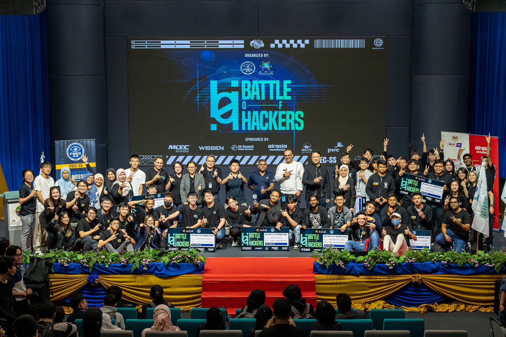 Winners of the ASEAN and local categories at the ASEAN Battle of Hackers (ABOH) 2023 joyfully celebrate their achievements with the organiser and sponsors on stage during the event's finale. 