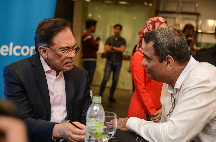 Anwar listening intently to Prabodh Sheth of ICEE International talk about his smart cooling system for buildings.