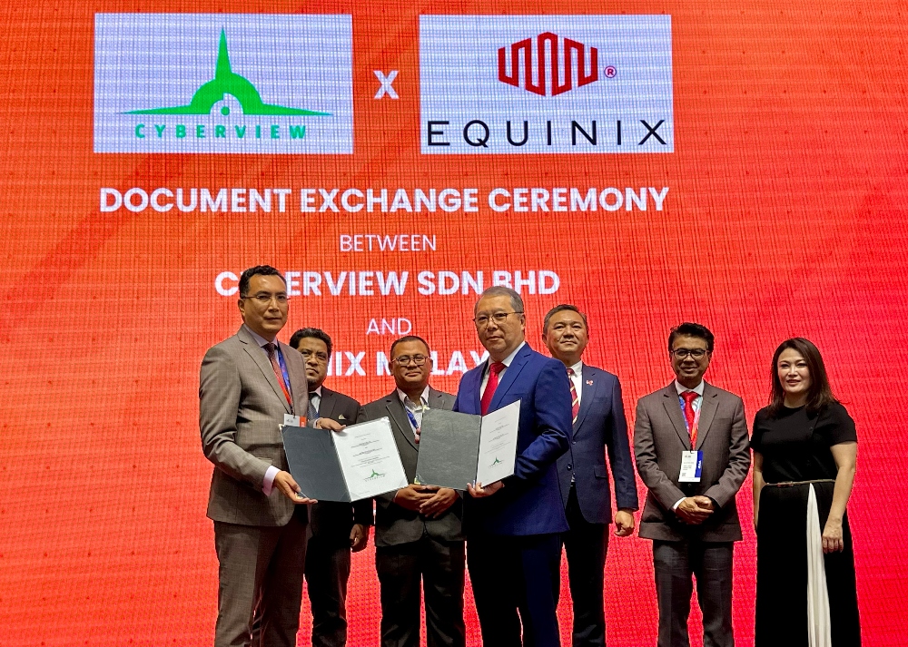 Kamarul Ariffin Abdul Samad, CEO, Cyberview Sdn. Bhd., exchanging documents with Cheam Tat Inn, managing director of Equinix Malaysia, at the document exchange ceremony between Equinix and Cyberview.