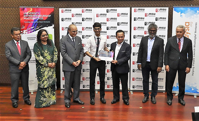 MOF National Strategy Unit senior deputy director Abu Bakar Jambol (third right) presenting certificates to students. Present on stage are Ministry of Entrepreneur Development senior director of digital economy and international relations Arividya Arimuthu (second left), MSU president Professor Dr Mohd Shukri Ab Yajid (third left) and StartupMalaysia.org programme lead and founder Dash Dhakshinamoorthy (second right)